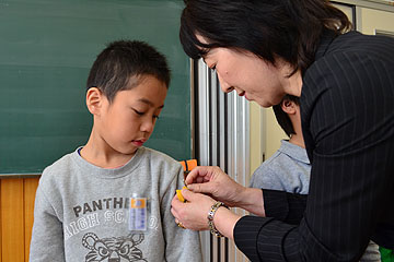 「ワッペンを腕に付けてもらい緊張気味」の画像