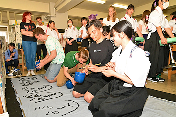 「初めて筆を持ったというスティーブンさん」の画像1